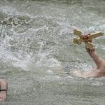 Traditii de Boboteaza Barbati care sar in apa si fete cu busuioc