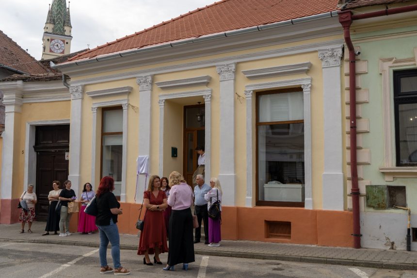 gest de solidaritate la mediash cladire iluminata in portocaliu si donatii de par pentru persoanele afectate de cancer